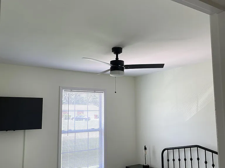 Private bedroom featuring a ceiling fan, window with blinds, and space for a full bed plus nightstand or desk.