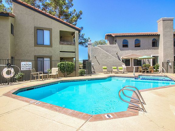 Courtyard pool and spa with long lounge chairs and umbrella-shaded picnic area.