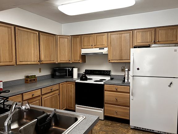 Kitchen with all appliances and pantry closet on adjacent wall.