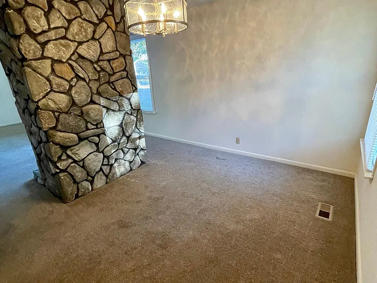 As you go behind the beautiful natural stone fireplace you have your dining area. It's is a nice size for a table of your choice. The chandelier is also on a dimmer switch for evening dining or give great light for seeing if not dimmed. Your choice.