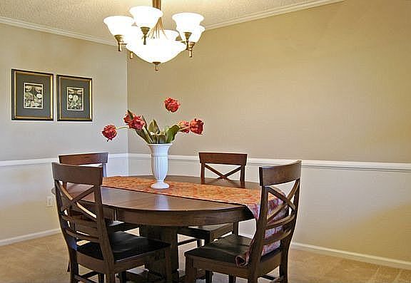 The elegant dining room has an updated light fixture, new paint & large window