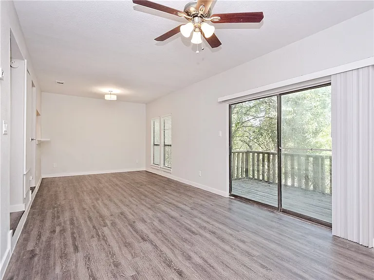 Living room view 2 showing 1st floor balcony entrance to overlook greenbelt.