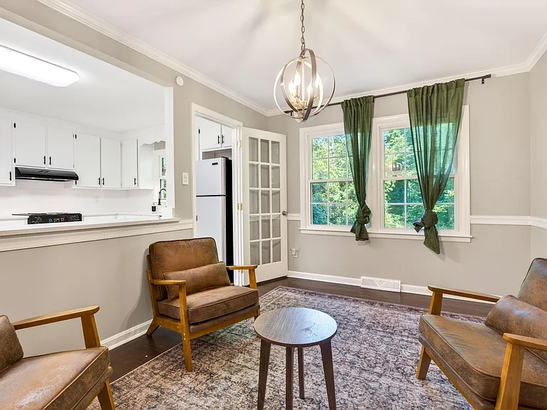 Open-concept living area with seating, large windows, and quick access to the adjacent kitchen and dining space.