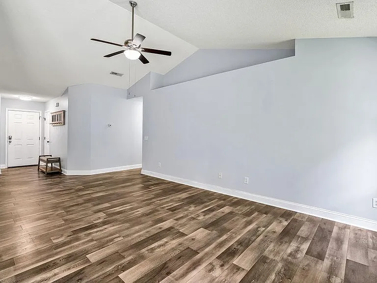 Living room with view of entry way (left) and hallway (center)