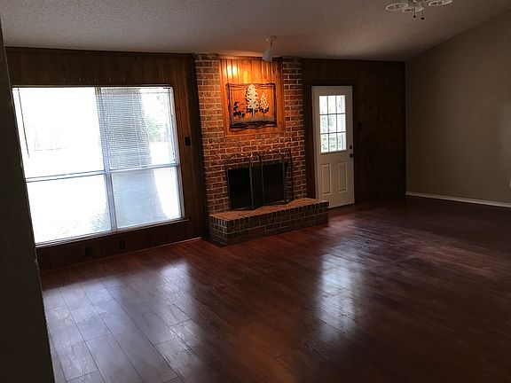 Living space has large window looking out onto shady backyar