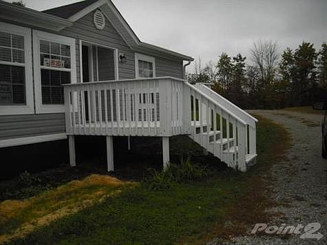 This mobile home is very nice with a sizable front deck and has a block foundation painted black. Also has a driveway with 2 entrances.