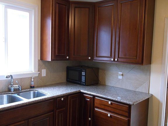 Kitchen has cherry wood cabinet and granite counter top