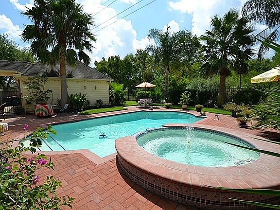 Backyard Beauty featuring a sparkling pool and spa surrounded by lavish landscaping in the fully fen