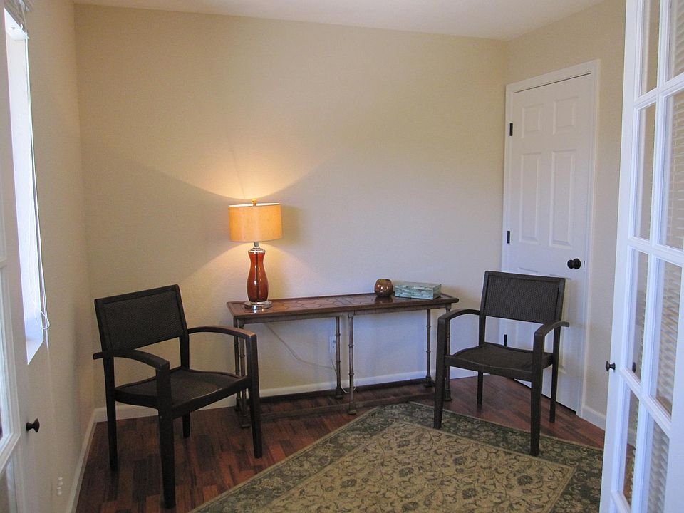 3rd room with ambient wall sconce, through French Doors off Family Room for single bed, office, or craft room. Window looks out upon patio.