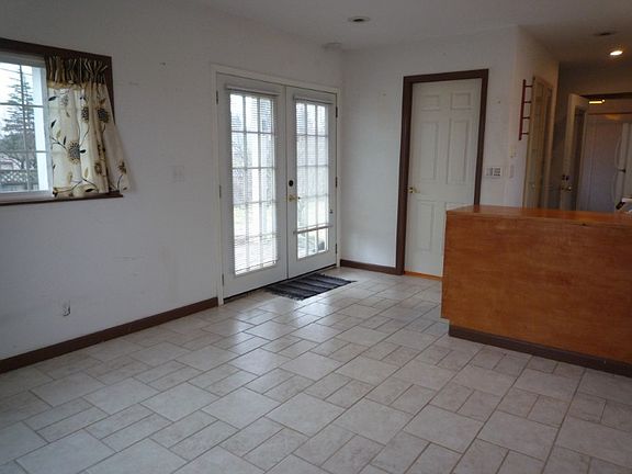 French doors, windows on every wall, ceramic tile flooring, recessed lighting.