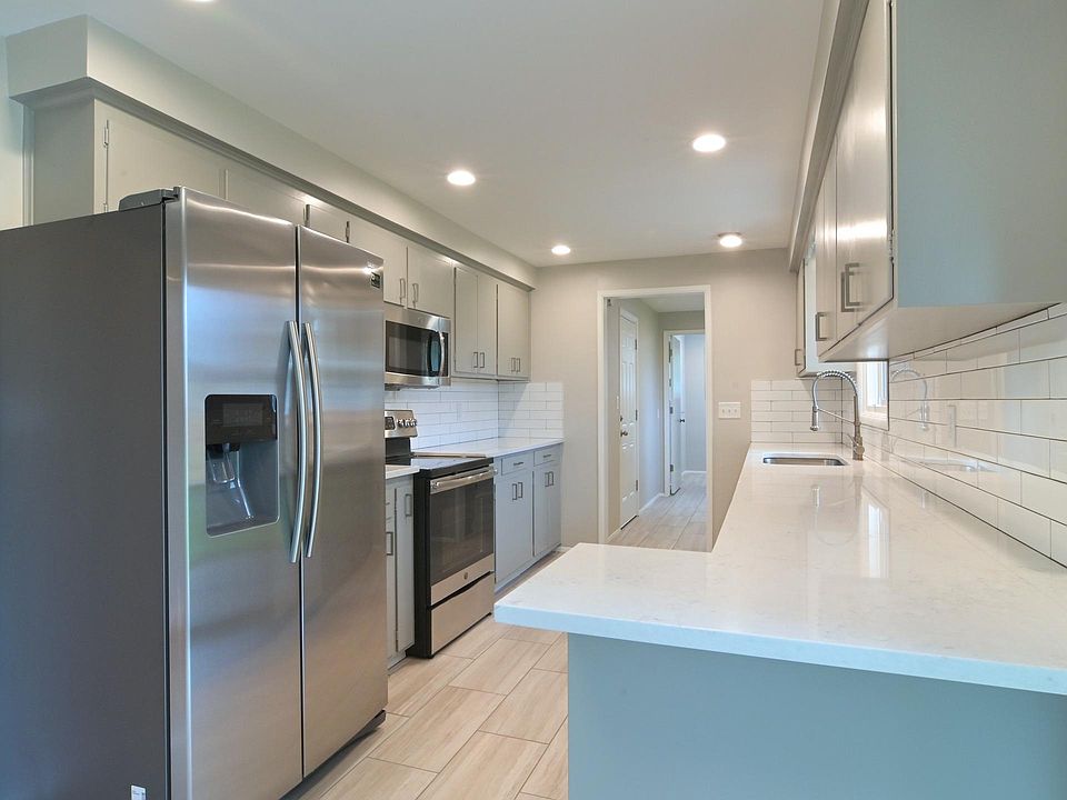 kitchen facing mudroom/ laundry area ( mudroom leads to garage and to the back yard) kitchen features: granite slab counters w/ stainless steel undermount sink, new porcelain tile floors, eat-in bar abundant cabinetry, brand new appliances , built in mi