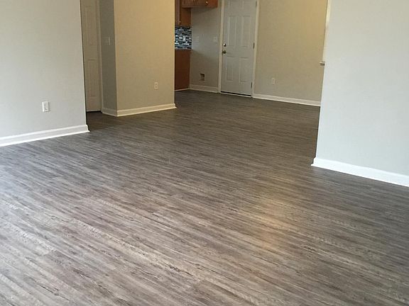 Living room view toward dining area, kitchen, laundry area, bedroom #3 and full bathroom.