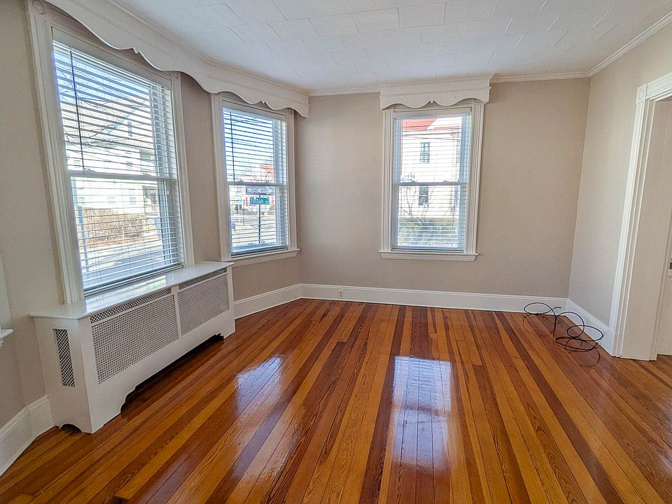 Bright and spacious living room with refinished hardwood floors and beautiful natural light