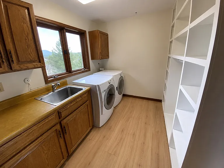 Large main floor laundry room w/ washer & dryer. Photo is digitally altered to show new LVP (original photos were done prior to the floor install)