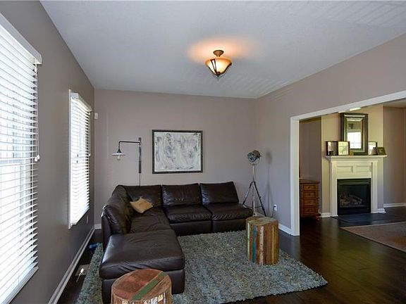 Living Room - Hand-scraped engineered wide plank flooring, open to the family room.