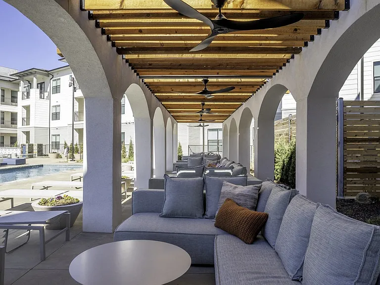 Unwind in style with poolside seating at Modera Walsh, complemented by the charming exterior featuring elegant arches.