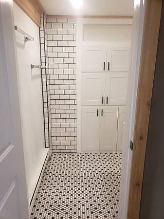 Bath entrance with a look at the built-in bathroom cabinet storage.