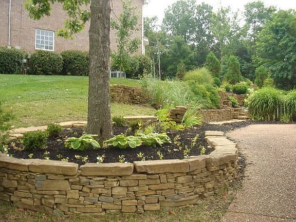 Gorgeous stacked stone flower beds line both sides of the house.