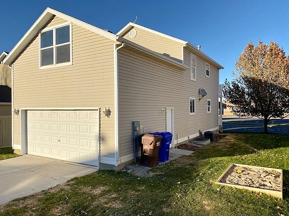 Side yard w/ sandbox and garage. Bonus room window.