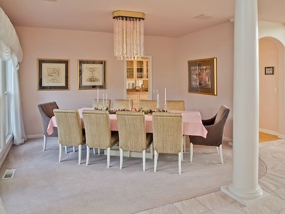 Main entry formal dining room with bay and main entry views. Butlers Pantry and kitchen to the left.