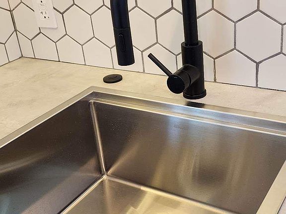 Beautiful stainless steel sink with garbage disposal below.