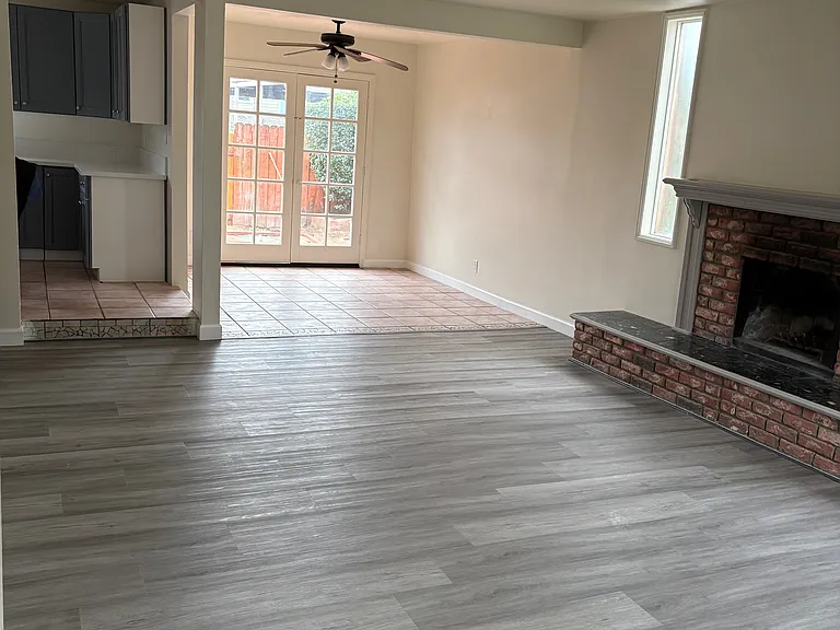 Looking left to the living room, dining room and entry to the kitchen. Notice the brick fireplace!