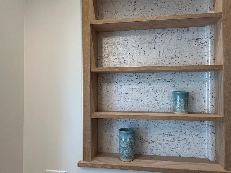 Kitchen nook featuring cork wallpaper and custom oak shelves