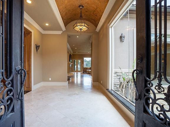 Impressive 8ft. Cantera Iron double entry doors lead to the foyer with barrel ceiling and incredible custom lighting.