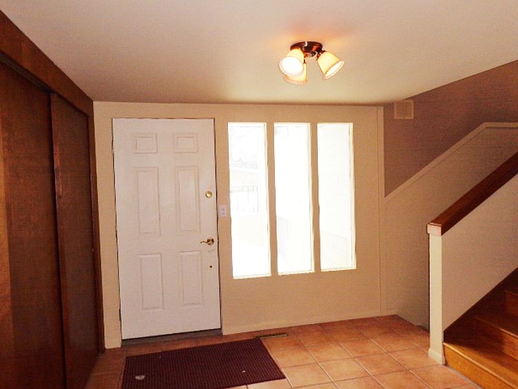 Foyer with open stairway and coat closet.