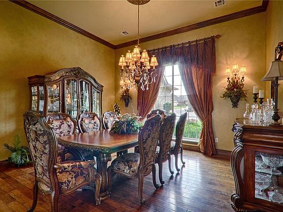 Formal Dining Room with large widow over looking front of home features beautiful hardwood floors and custom draperies