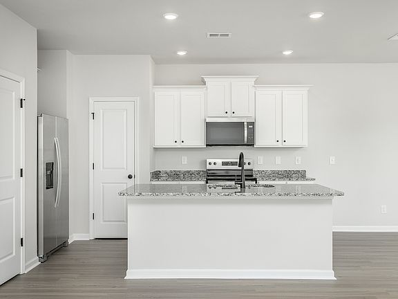The kitchen has designer wood cabinetry
