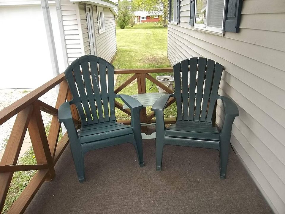 Two Adirondack porch chairs welcomes you to carpeted side porch