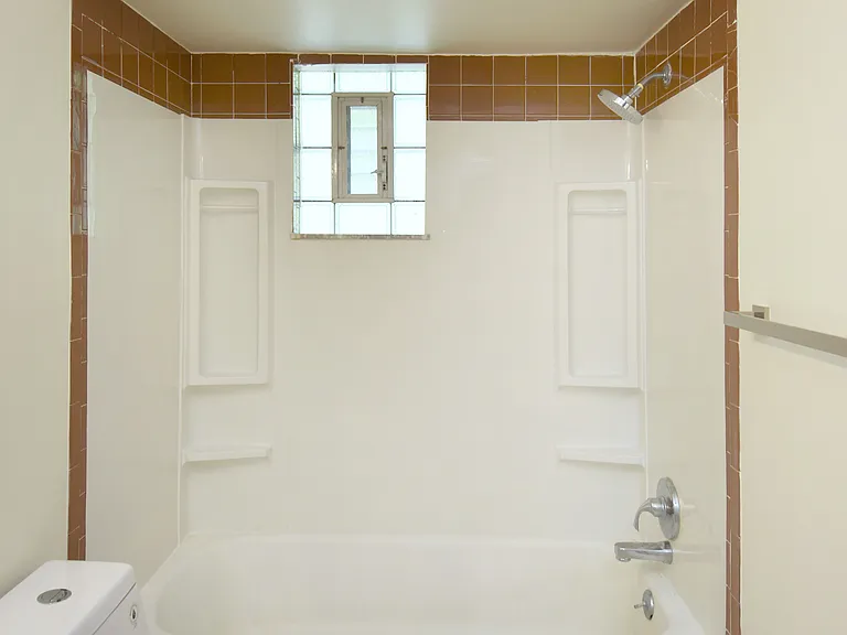 Bathtub has new faucet fixtures and towel bars throughout.