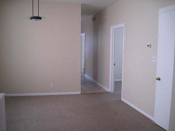 Dining room with front door entrance, middle bedroom, and hallway leading into the kitchen