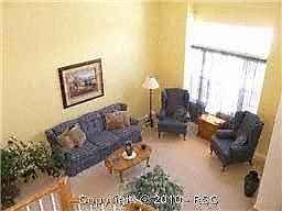 The living room features soaring ceilings entered from a hardwood foyer 