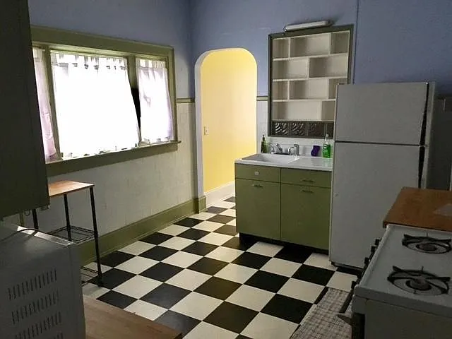Dine-in kitchen with butcher block countertops and gas stove/oven. (Entranceway to half bedroom or home office.