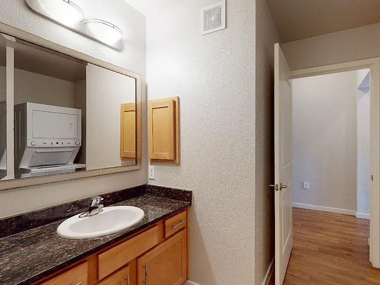 Apartment bathroom with wood-style flooring.