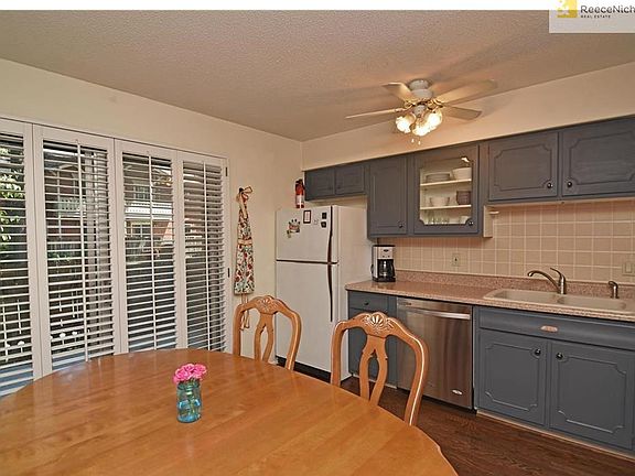 Grey painted cabinets, neutral tile backsplash, and plantation shutters on patio slider!