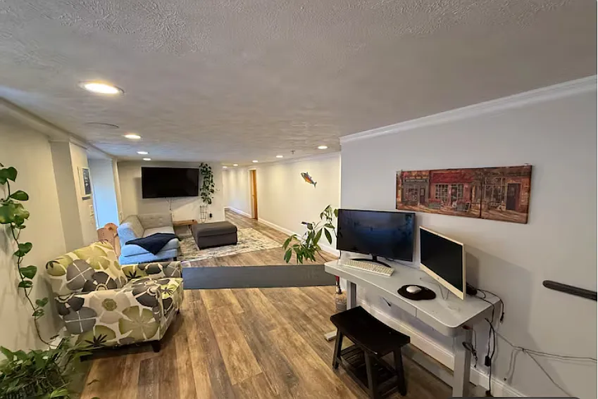 Another view of the open living space featuring a large TV setup and direct access to the outdoors. - 6076 Smith Rd