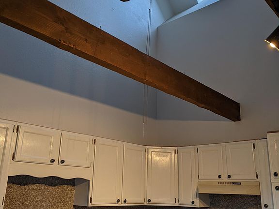 vaulted kitchen with skylights and ceiling fan