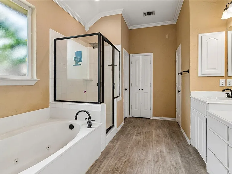 Primary bath with dual sink, separate shower and bath and large walk in closet