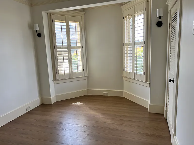 Primary bedroom - new LVT flooring, plantation shutters with block out blinds, bay window, walk-in closet.