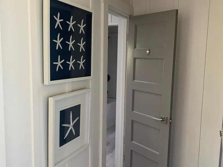 Hallway leading into large second bath with tub and shower