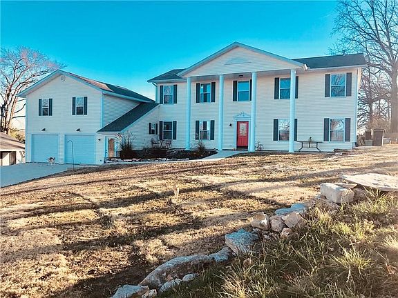 Beautiful colonial style home with detached shop and living quarters.  On 5 level acres.