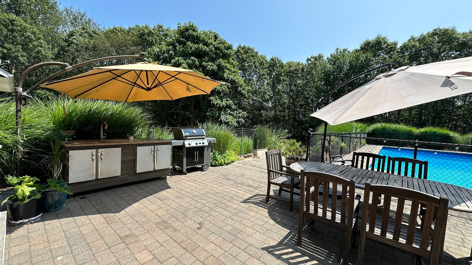  outdoor kitchen and dining area on sunlit patio