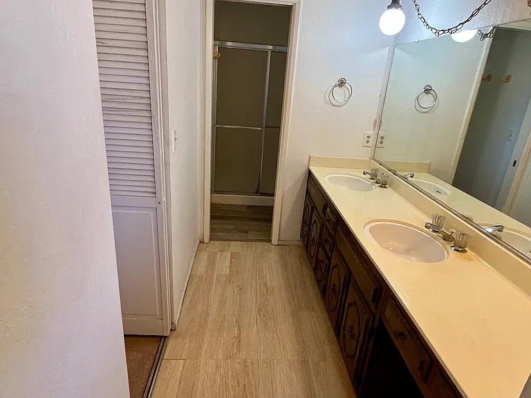 Primary bath vanity area with dual sinks, ample counter space, and an oversized mirror.