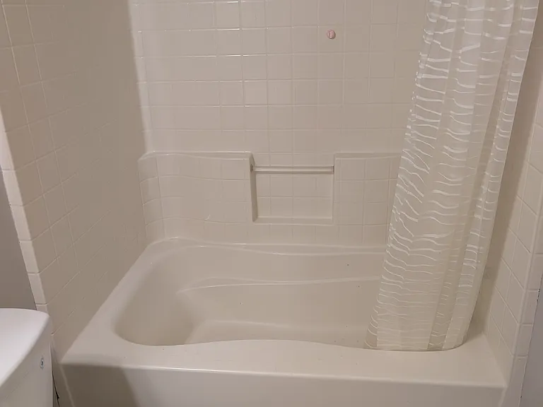 Full bathroom featuring a clean tub and shower surround