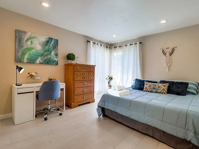 Enjoy lots of natural light in Bedroom 1 w/ a cozy king bed & workspace for productivity