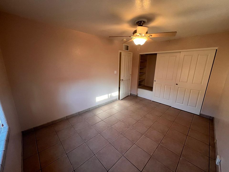 Spacious main room with ceiling fan and window with backyard view.