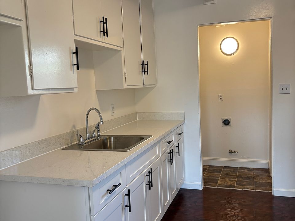 New kitchen cabinets, new sink, new flooring. The space pictured in the back is where washer dryer hookups. New refrigerator will be installed next to cabinets. Not pictured